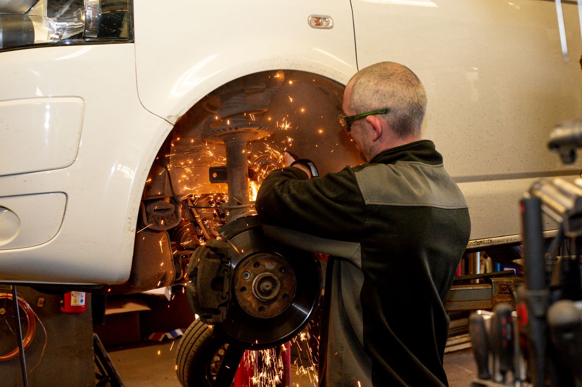 Anställd arbetar i verkstaden, kör med vinkelslip.